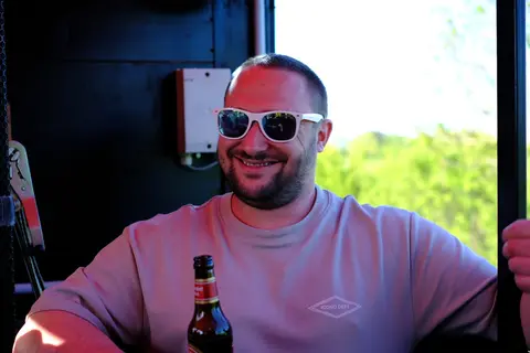 Ein Gast mit Getränk lächelt in die Kamera