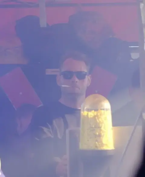 Ein Gast mit Sonnenbrille hinter dem Bierturm