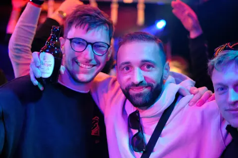 Zwei Freunde posieren im Partylicht