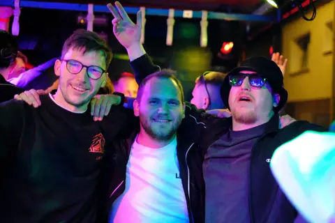 Drei Freunde feiern im Wagen